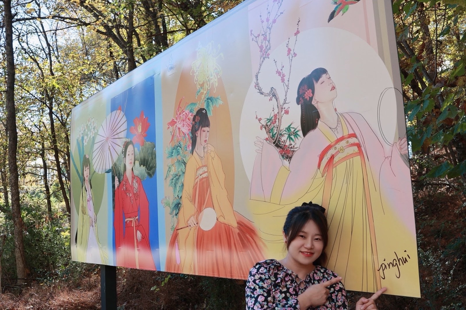 Pinghui Ren standing with her Four Seasons outdoor billboard at the North Carolina Museum of Art